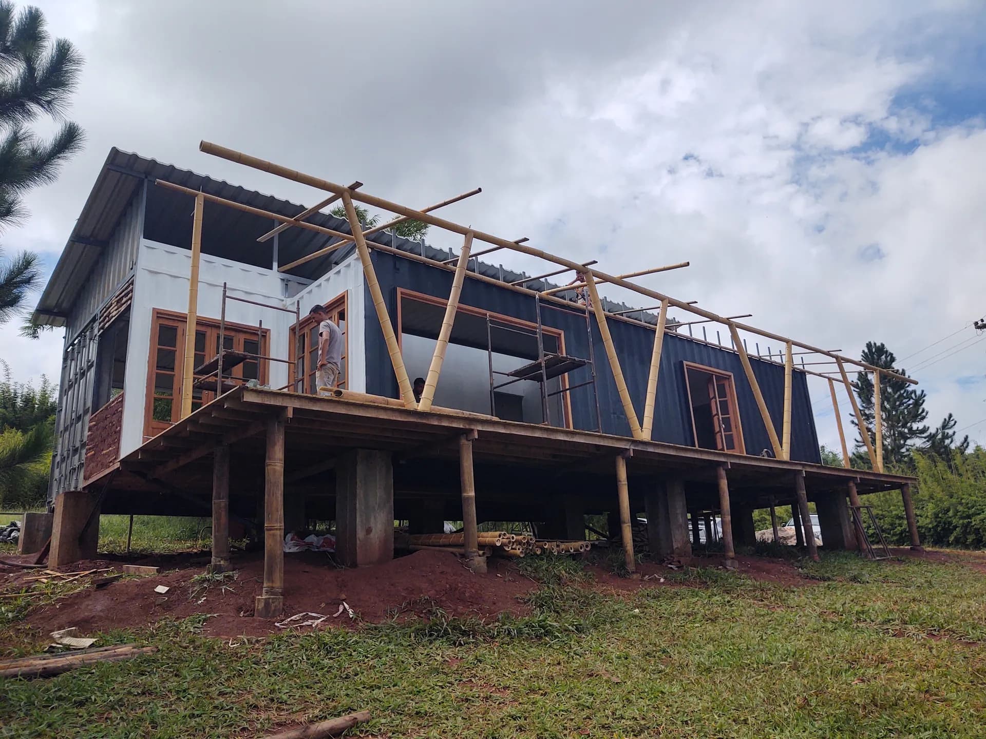 Montagem da estrutura de cobertura em bambu sobre contêineres marítimos no protótipo EcoCasa, Pardinho/SP.