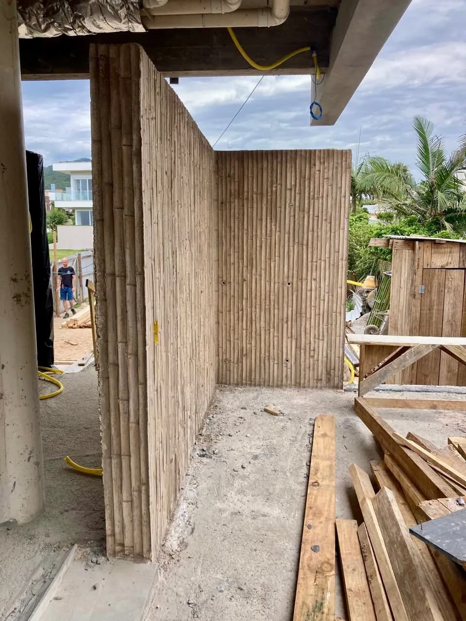 Parede de concreto com estampa de bambu, com a fôrma ainda posicionada em obra.