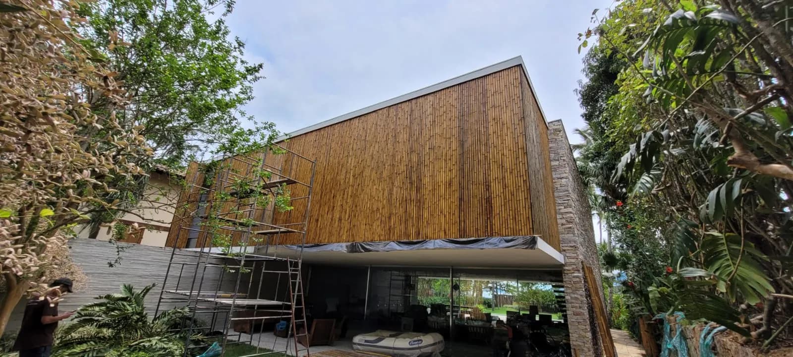 Volume revestido em bambu em balanço sobre a base de concreto da Casa da Praia da Feiticeira.
