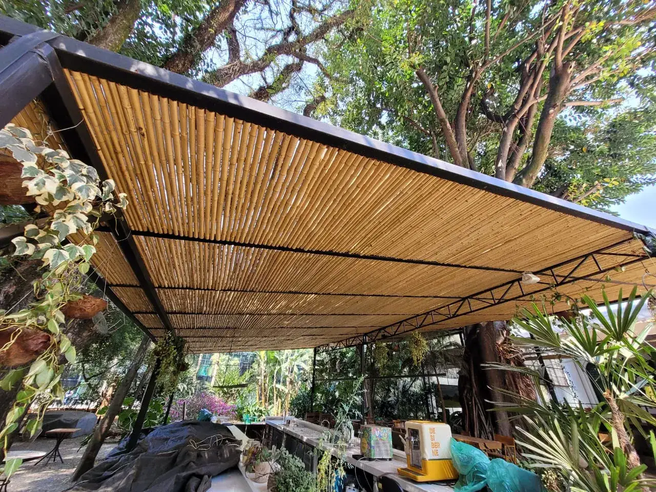 Capim Santo — área externa: deck sob cobertura de bambu, integrado ao jardim.