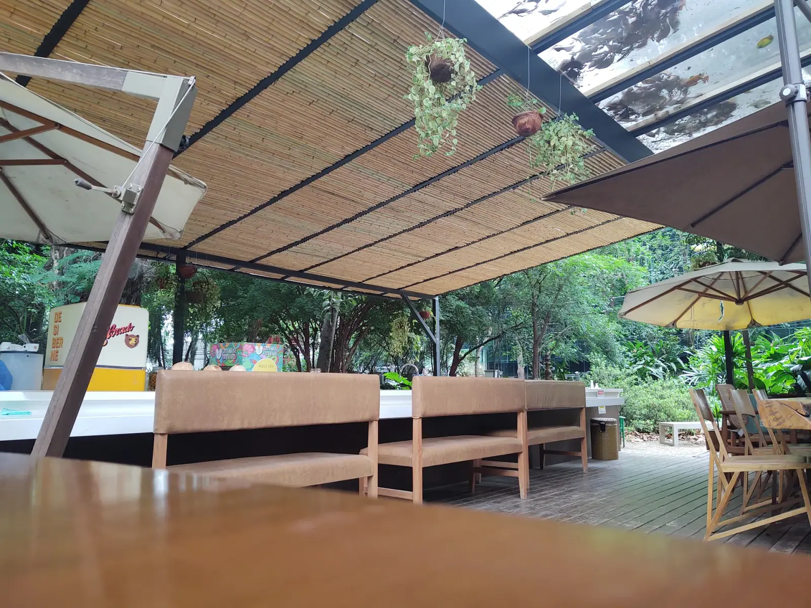 Capim Santo — área externa: deck sob cobertura de bambu, integrado ao jardim.
