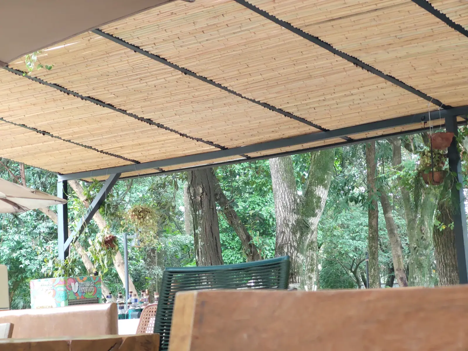 Capim Santo — área externa: deck sob cobertura de bambu, integrado ao jardim.