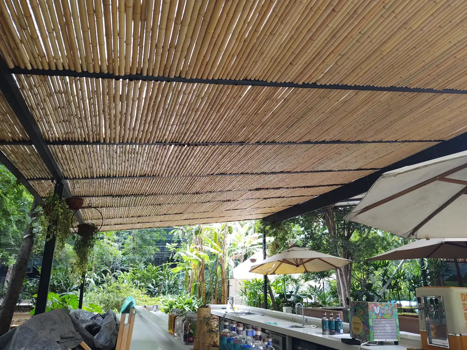 Capim Santo — área externa: deck sob cobertura de bambu, integrado ao jardim.