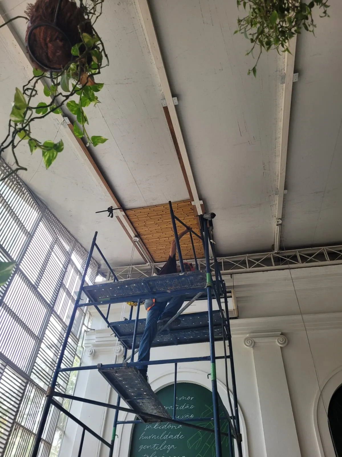 Instalação de painéis de bambu no forro do Capim Santo, com andaime, durante a obra.