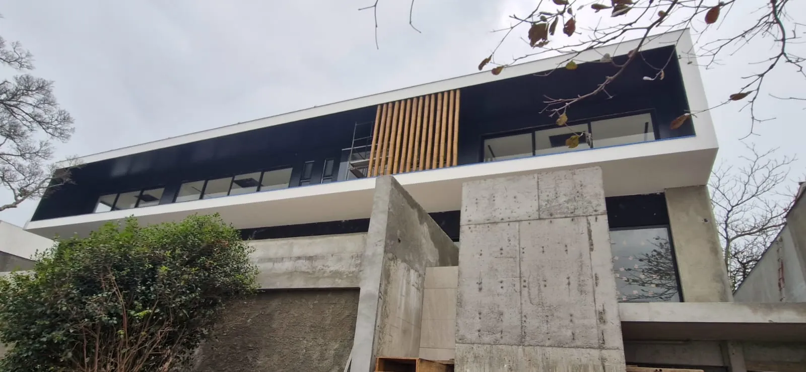 Casa Bombinhas: fachada com brise e revestimento de bambu, registro de obra.