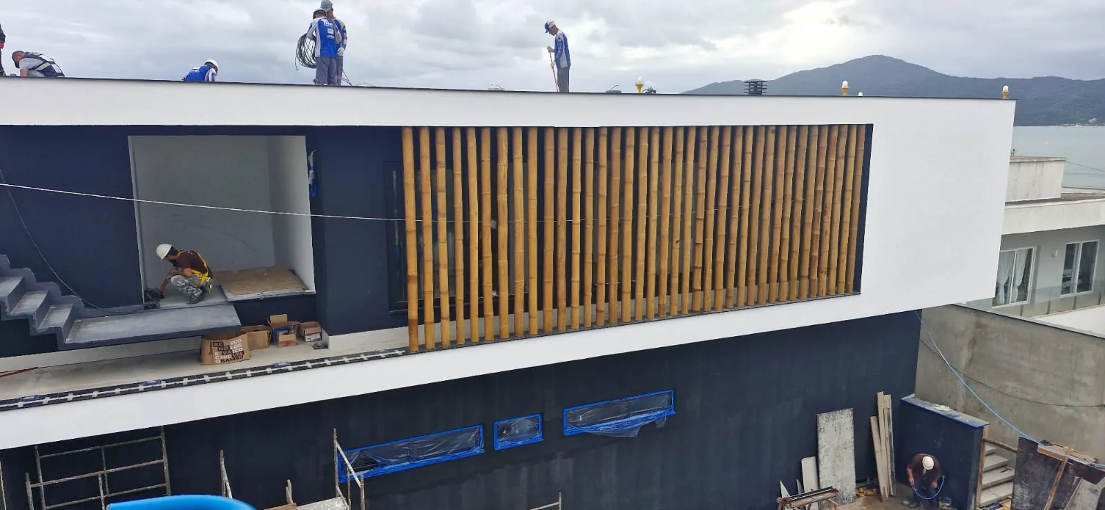 Casa Bombinhas: fachada com brise e revestimento de bambu, registro de obra.