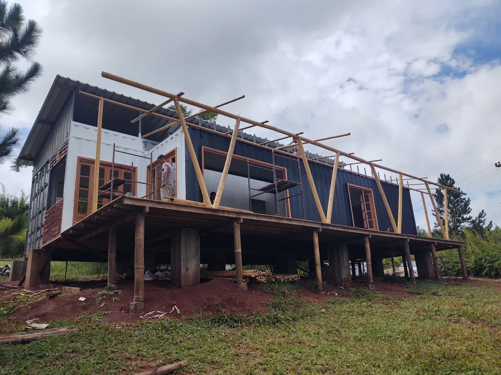 Montagem da estrutura de cobertura em bambu sobre contêineres marítimos no protótipo EcoCasa, Pardinho/SP.