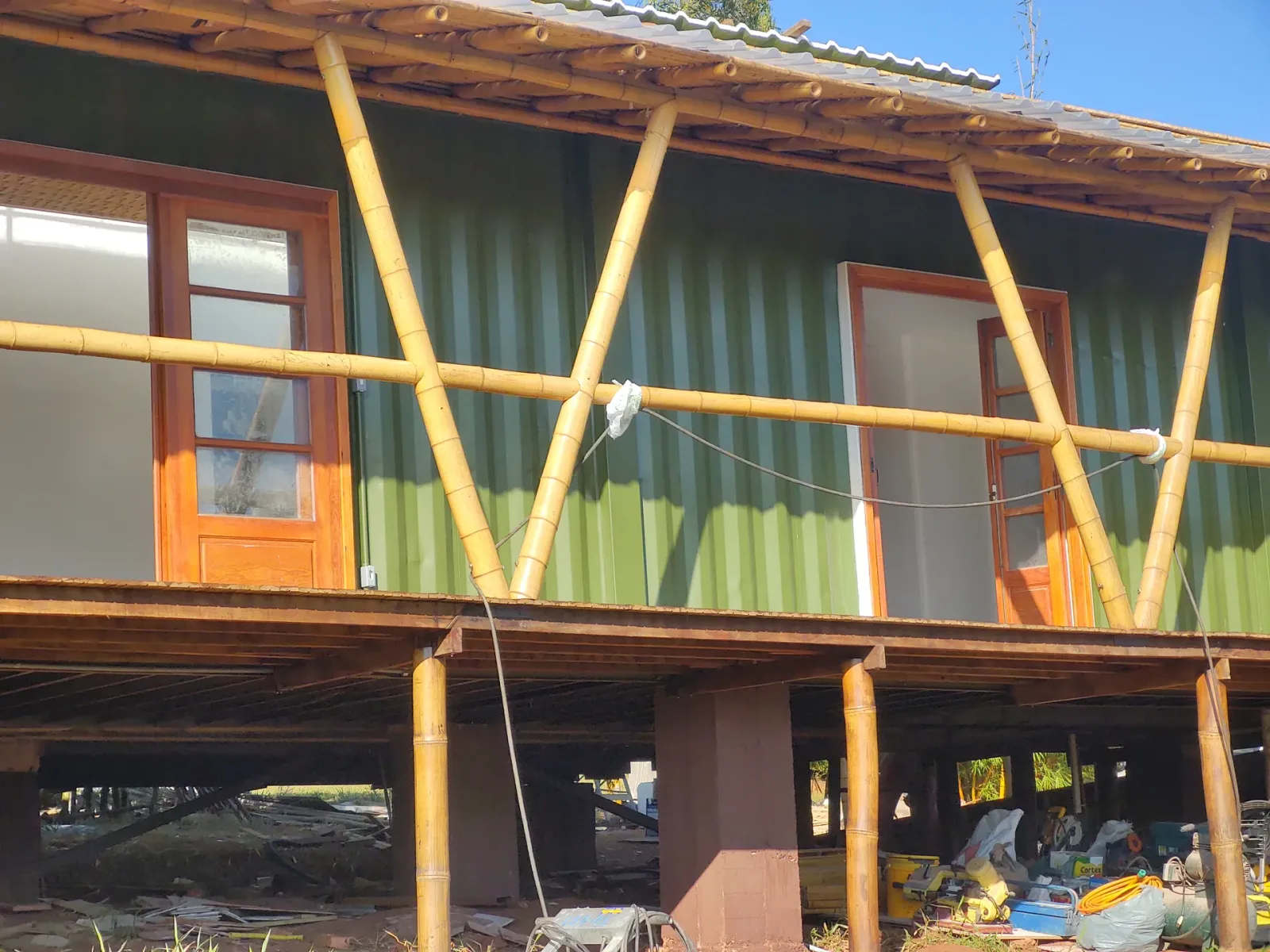 Acabamento e pintura das esquadrias de madeira sobre o contêiner verde do protótipo EcoCasa.