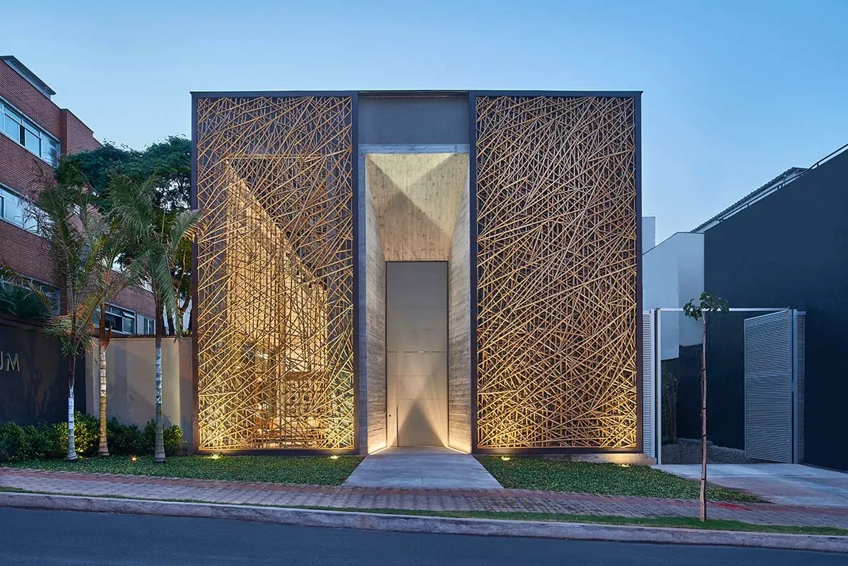 Fachada da loja Tetum (Líder Interiores) com treliça de bambu iluminada ao entardecer.