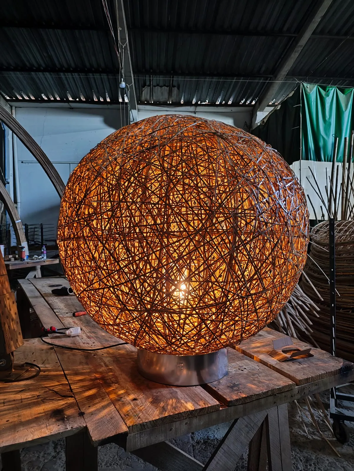 Luminária Ninho acesa sobre base de aço, trama artesanal de bambu — Studio Objeto / Arthur Casas.