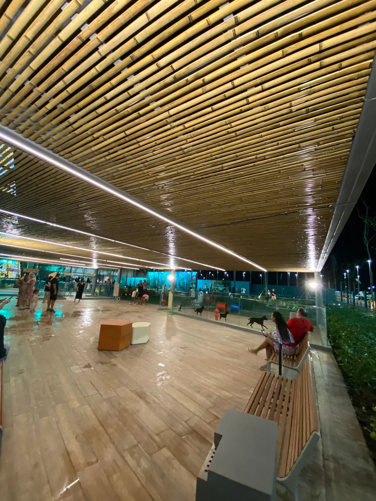 Parcão Multiplan finalizado à noite: forro ripado de bambu iluminado sobre o deck.